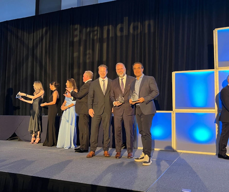 Kevin Jones and Phil Speed from The Learning Network, and a representative from Purolator accepting awards from the Brandon Hall Group